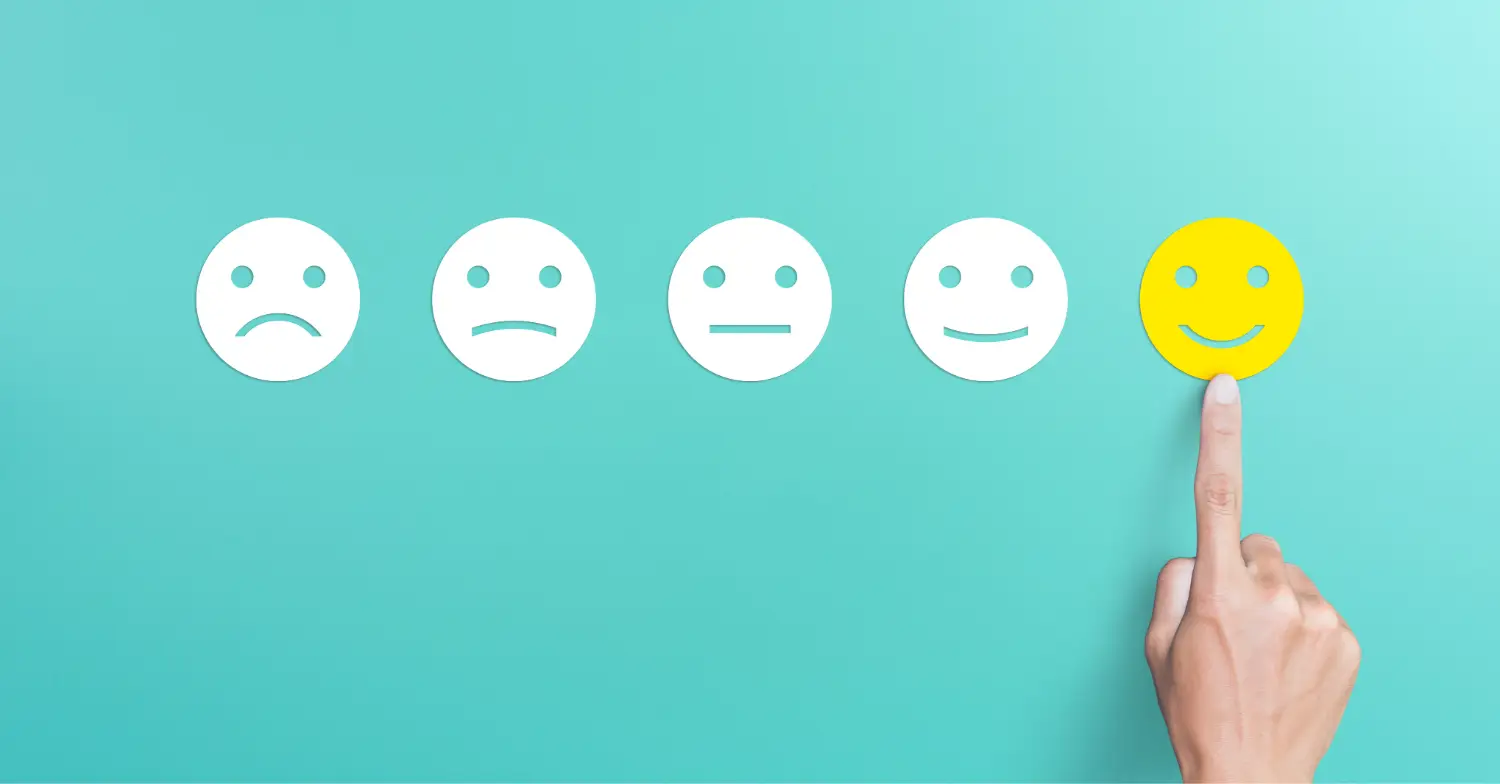 Hand selecting a happy face rating in a customer feedback survey