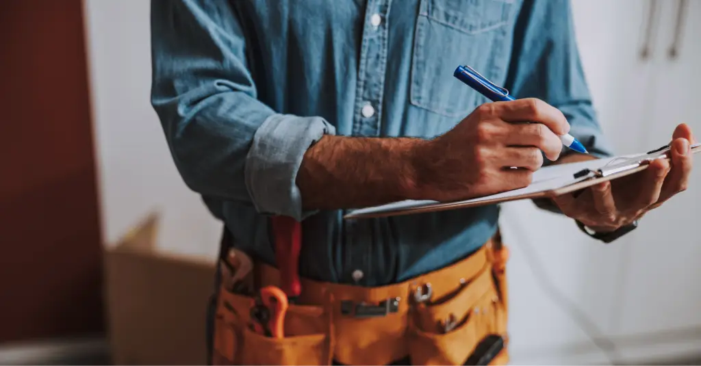Home service contractor writing on a clipboard to track lead performance and booked jobs